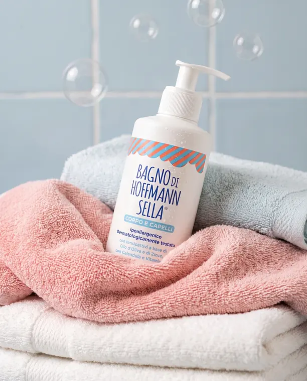 Flacone di Bagno di Hoffmann Sella corpo e capelli su asciugamani morbidi con bolle di sapone
