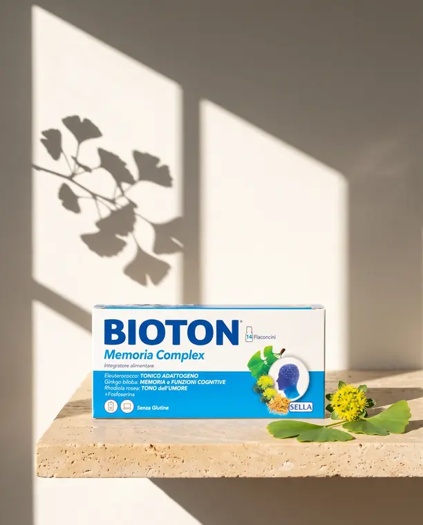 Confezione di Bioton Memoria Complex su mensola di travertino con foglie di ginkgo e ombra della pianta
