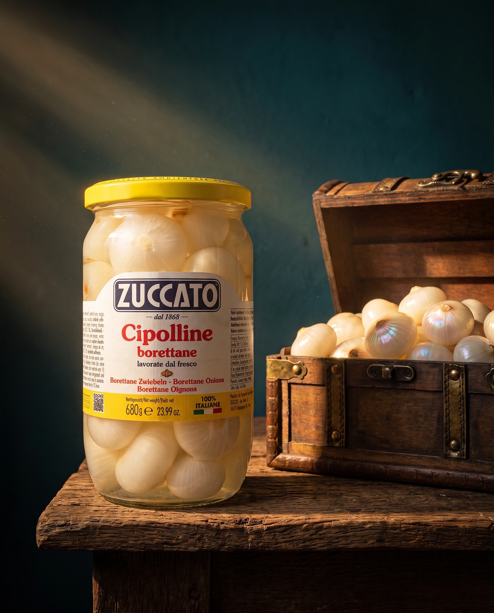 Vasetto di cipolline borettane Zuccato accanto a un baule di legno pieno di cipolline